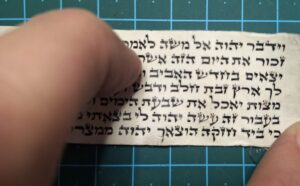 סופר סת"ם בודק פרשיות תפילין של יד שנפסלו